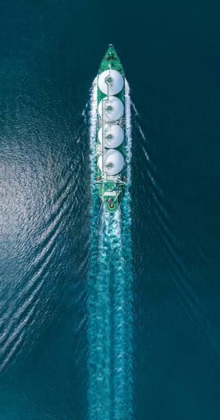 Aerial top view LNG Tanker ship (Liquified Natural Gas) with contrail in the ocean sea ship carrying container and running for export from container international port to custom ocean concept freight shipping by ship service vista aérea superior buque cisterna de gnl (gas natural licuado) con estela en el océano barco que transporta contenedores y funciona para la exportación desde el puerto internacional de contenedores al concepto de envío de carga oceánica personalizad