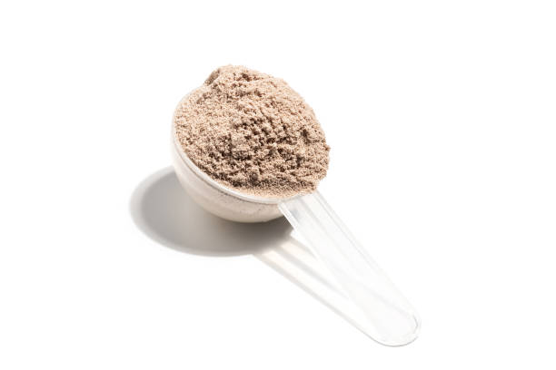 istock Chocolate whey protein powder in a plastic measuring spoon, isolated on white background 1662818284