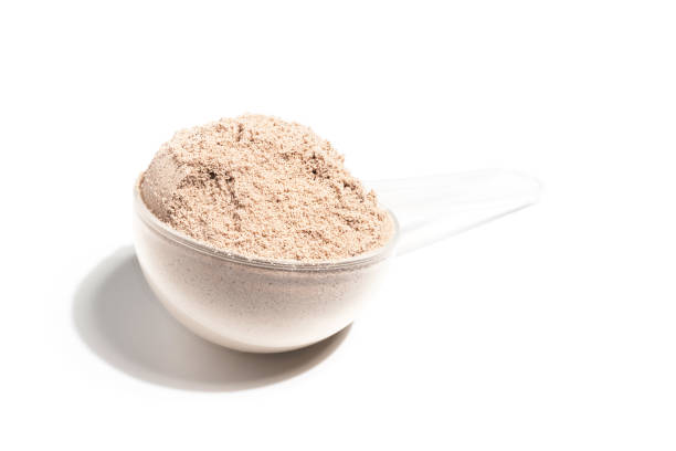 istock Chocolate whey protein powder in a plastic measuring spoon, isolated on white background 1662818374