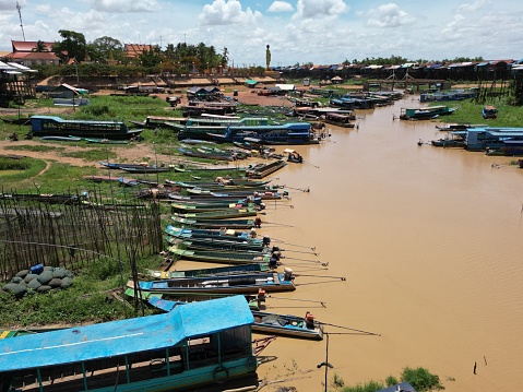 A scenic view of a floating village in Cambodia with multiple boats on the river