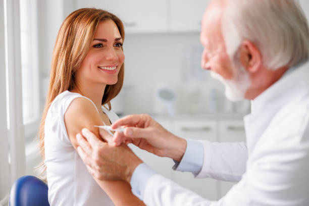 Doctor applying vaccine to patient stock photo