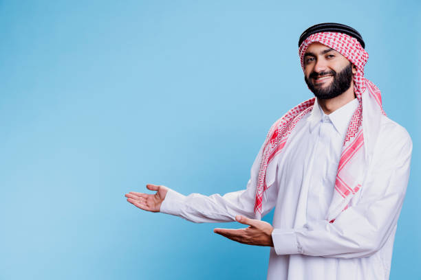 istock Arab man in thobe pointing to side 1662874324
