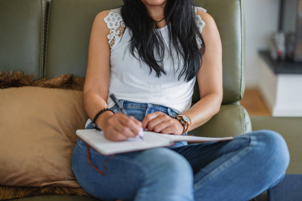 istock Close Up Of A Woman Journaling While Sitting On A Couch 1662883384