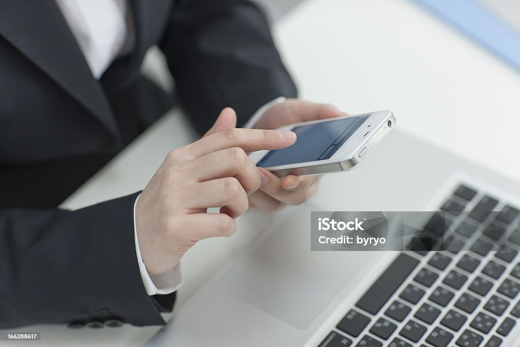 The businesswoman who operates a smartphone Business Desktop PC Stock Photo