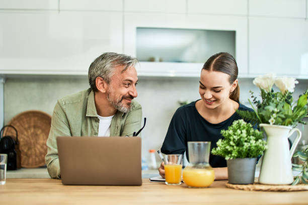 istock A father and daughter sitting at the kitchen table and using a laptop. 1662894820