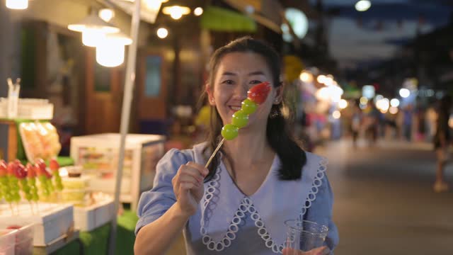 Asian woman visits local market and eats local food at local market in Thailand