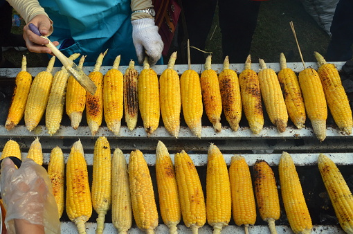 The process of making roasted corn using traditional methods in Indonesia.