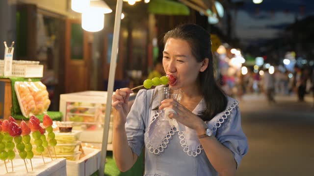 Asian woman visits local market and eats local food at local market in Thailand