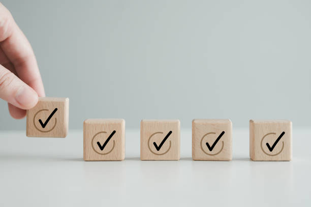 istock Checklist, To do list, Task list, Survey and assessment. Quality Control. Goals achievement and business success. Hand holding Check mark icon on wooden blocks to complete check list. 1662910276