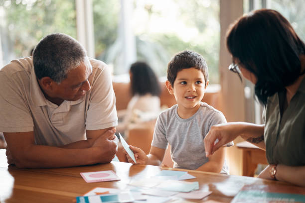 istock Home school, learning and parents support child with lesson and flash cards for education. Studying, kid and grandfather with teaching, communication and bonding from development and conversation 1662914157