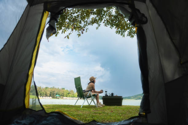 istock Hipster Asian woman camper relaxing and enjoying camping alone. 1662921149