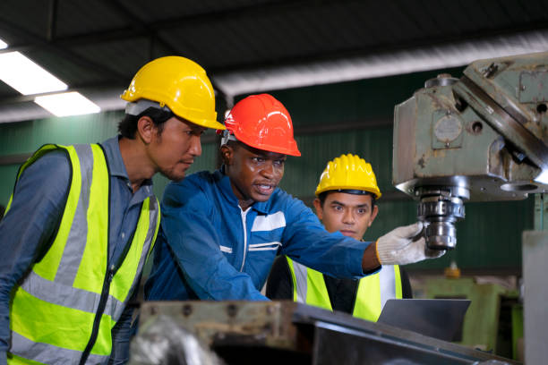 Blue collar workers work at machinery factory. stock photo