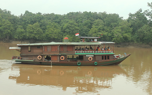 Palangka Raya City, Central Kalimantan, Indonesia - January 26, 2014 - River cruisers take tourists across the Kahayan River in Palangka Raya City to enjoy the surrounding natural scenery.