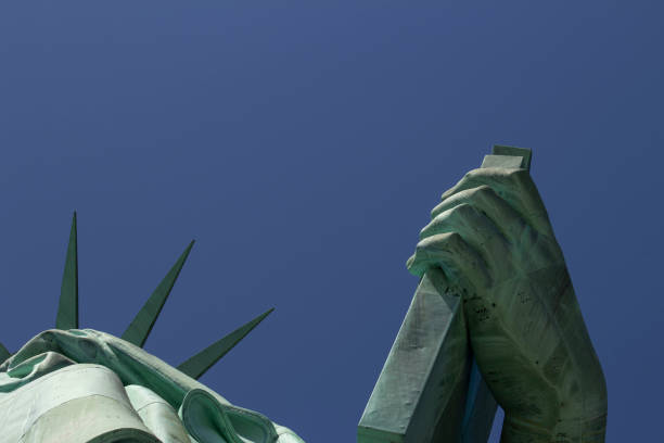 Liberty Island, New York, USA: The Statue of Liberty designed by Alexandre Gustave Eiffel on a blue sky with white clouds background with 4th of July writing visible
