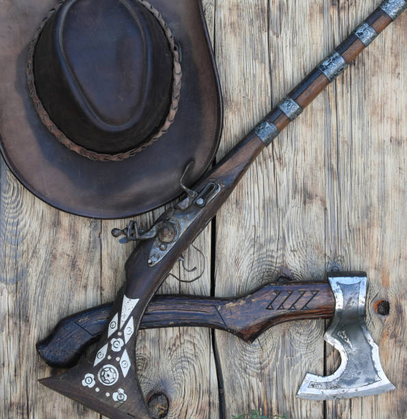 istock ax and rifle on old wooden background 1663008958