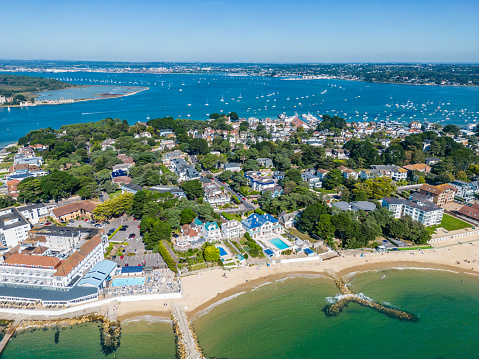 Beach front properties on Sandbanks with Poole Harbour with Bournemouth in distance