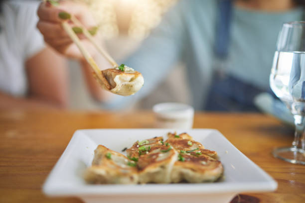 istock Table, plate and chopsticks with a dumpling at a restaurant for food, Asian culture or fine dining. Health, hungry and a person with dinner, eating lunch or enjoying a fried dish or cuisine at a cafe 1663011606