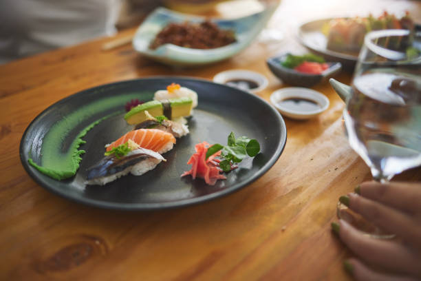 istock Plate, table and sushi with a person at a restaurant for fish, lunch or seafood dinner. Closeup, hungry and people at a cafe for fine dining, Chinese food or eating Asian cuisine for a meal together 1663011622