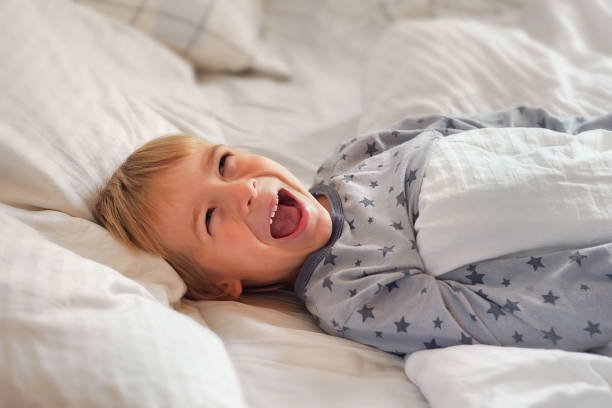 istock 5 years Boy joking, sticking tongue out with silly expression. Child making face. Funny foolishness portrait of little boy in white bedroom. Adorable caucasian kid making crazy and comical gesture. 1663012011