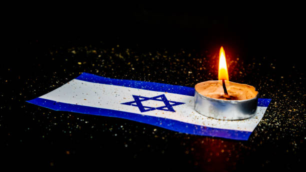 istock Israeli flag and candles burning above it, Holocaust memory day 1663012205
