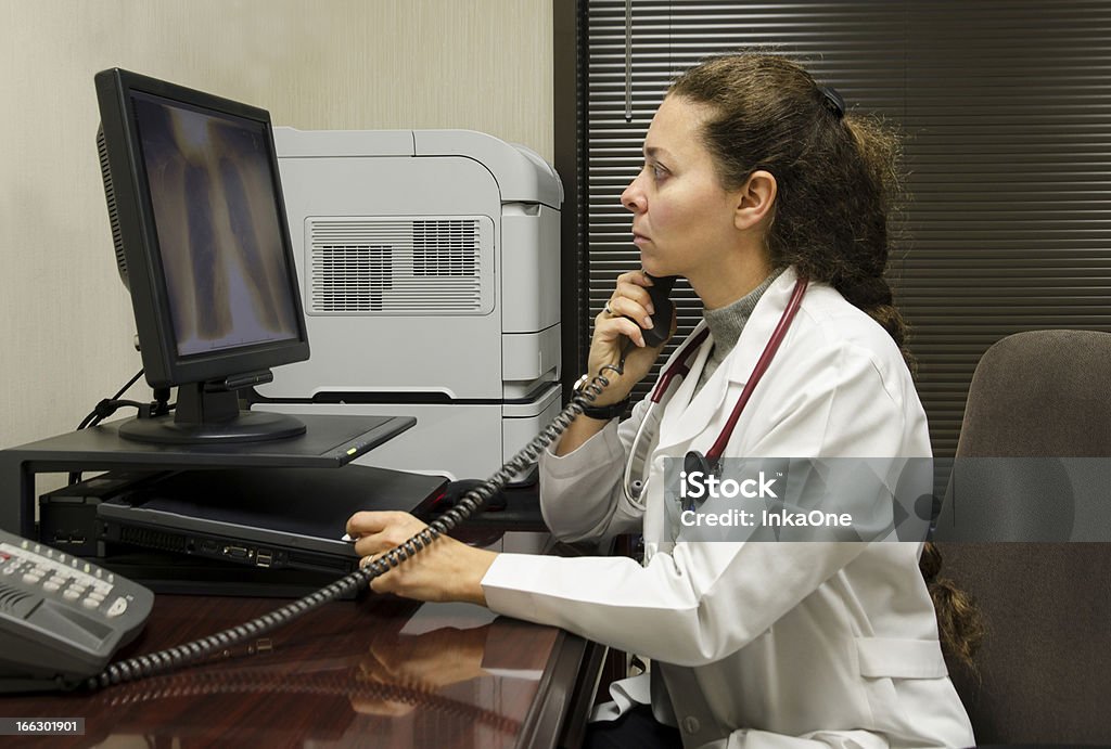 Femmina medico esaminando una radiografia - Foto stock royalty-free di Pulmonologist