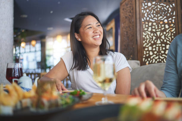 istock Japanese woman, sushi restaurant and smile for eating, thinking and conversation for fine dining at party. Asian friends, fish and healthy with culture, traditional or fast food in diner, bar or shop 1663019014