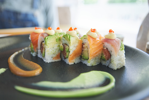 Asian, sushi and plate of food at a restaurant for dinner or lunch meal at healthy Japanese cafe on table. Plate, cuisine and fine dining takeaway or seafood from a Salmon menu for diet or nutrition
