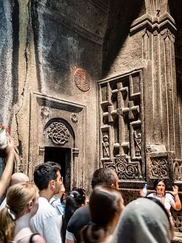 Goght, Armenia - August 25, 2023: excursion in medieval rock monastery of Geghard in Armenia. Geghard being partially carved out of adjacent mountain, it is listed as UNESCO World Heritage Site