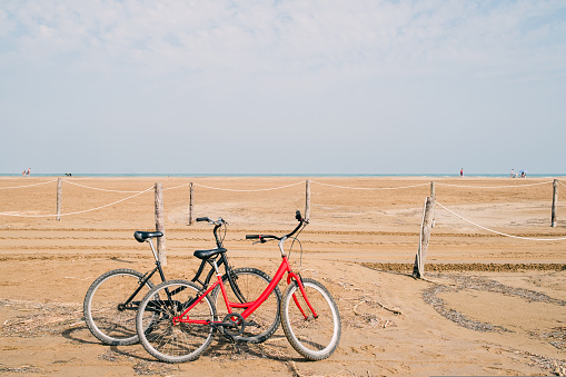 two old bikes at the beach in front of the sea. High quality photo