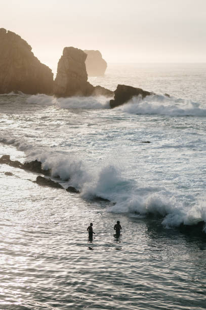 istock Silhouette of two people in the ocean 1663078694