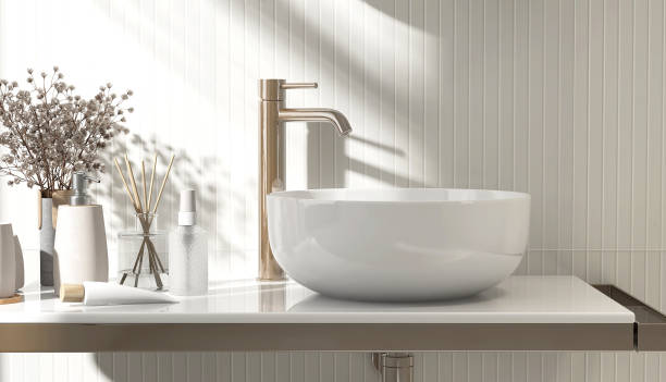 istock White stone vanity counter, modern bowl washbasin, chrome faucet, aromatherapy diffuser, soap dispenser, flower bouquet in sunlight, shadow on cream wood wainscot wall 1663080288