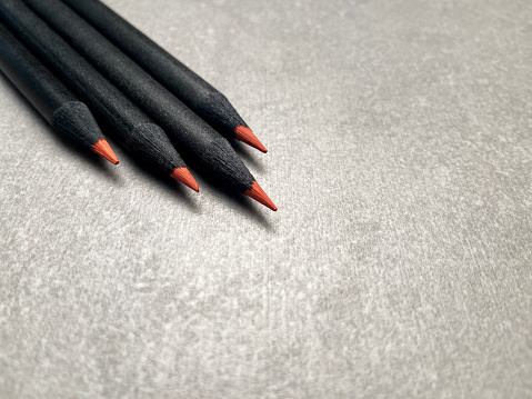 Black pencils with red tip on gray background and copy space