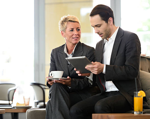 biznes kobieta i mężczyzna z cyfrowy tablet w kawiarni - digital tablet young men women short hair zdjęcia i obrazy z banku zdjęć