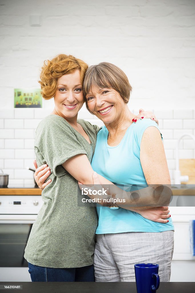 Mãe e filha em pé na cozinha - Royalty-free Abraçar Foto de stock