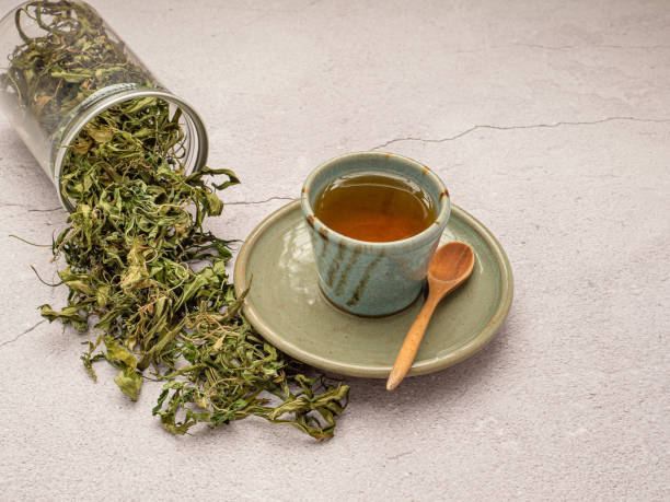 istock Dry cannabis leaf tea outside a box and marijuana tea cup on a table 1663117383