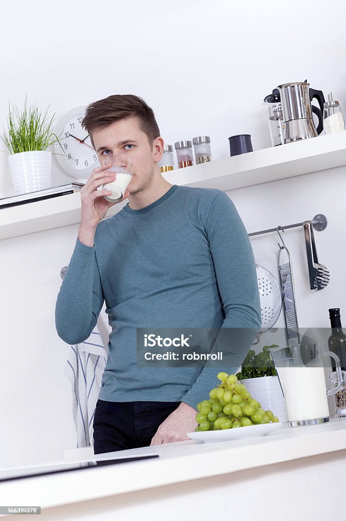 Jovem beber um copo de leite na cozinha - Foto de stock de Adulto royalty-free