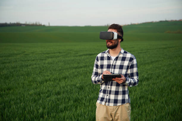 istock In virtual reality glasses. Handsome young man is on agricultural field 1663149398