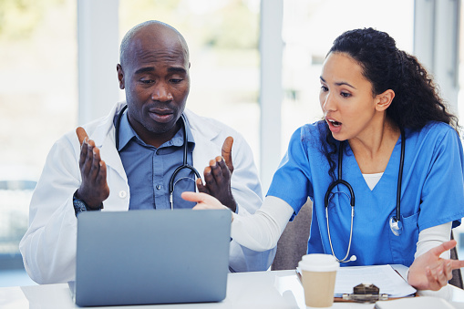 Shocked, surprised and laptop of doctors with research, hospital meeting and medical results fail, risk or crisis. Discussion, confused and stress healthcare nurses, team or black people on computer
