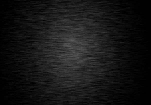 Black metal steel plate and metallic texture on a dark background and a spot in the middle stock photo