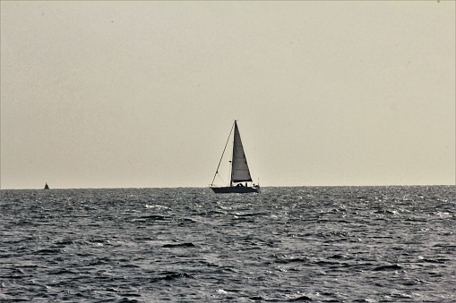 Yacht Sailing along the horizon on calm waters