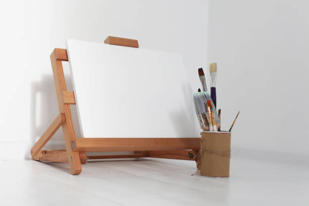 istock Empty copy space canwas on wood easel and paintbrush in artistic workshop interior. 1663161085