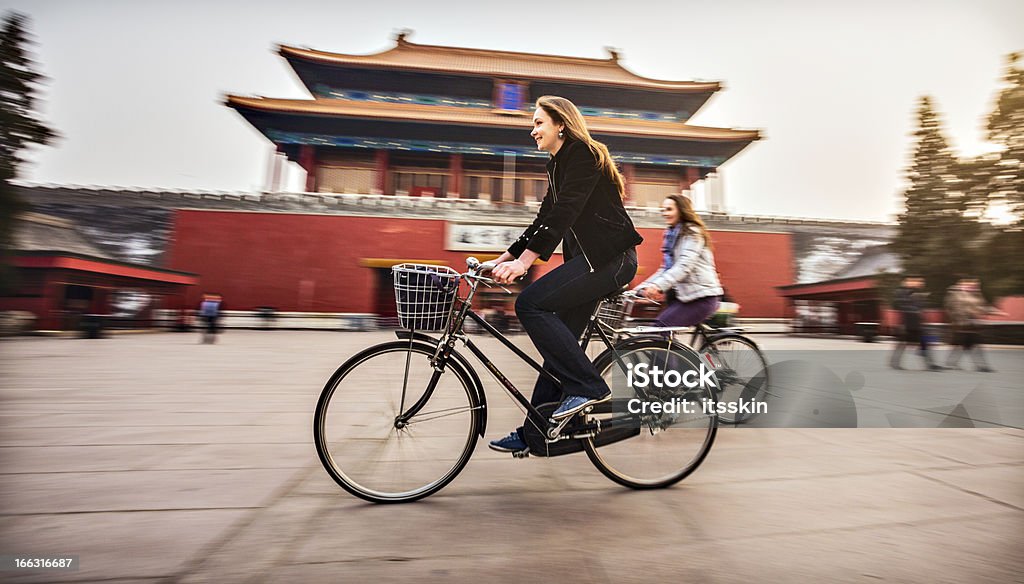 Tourists in Beijing riding bikes Friends riding retro bicycles along forbidden city China - East Asia Stock Photo