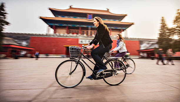 Tourists in Beijing riding bikes Friends riding retro bicycles along forbidden city beijing stock pictures, royalty-free photos & images