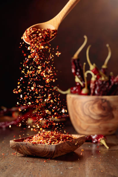 istock Chilli flakes are poured into a wooden dish. 1663168951
