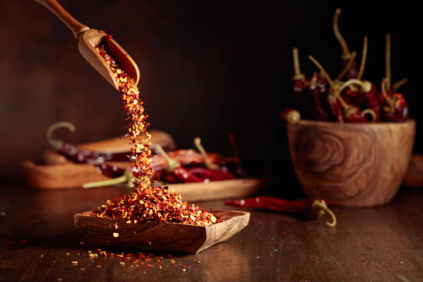 istock Chilli flakes are poured into a wooden dish. 1663168976