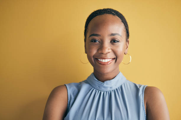 istock Face, happy and black woman, designer and entrepreneur in studio isolated on a yellow background mockup space. Portrait, smile and creative African professional, worker or startup employee in Kenya 1663171128
