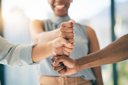 Fist bump, support or business people for motivation or teamwork for mission or collaboration. Partnership, hands closeup or employees meeting in huddle with goal, vision or group solidarity together