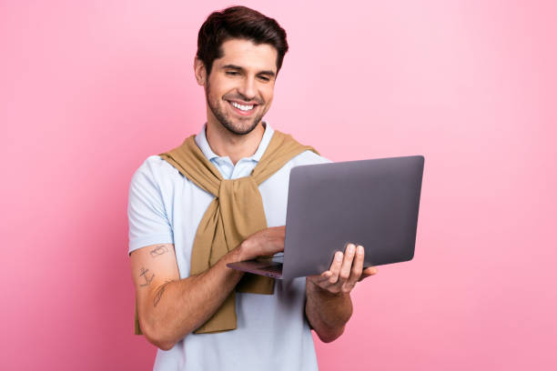 istock Photo of cheerful nice person beaming smile use wireless netbook networking isolated on pink color background 1663198326