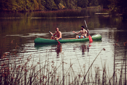 Males In Canoe Discussing Which River Route To Take