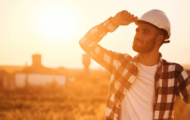 istock Touching the hard hat. Man is outdoors against sunset light. Rural scene 1663234981
